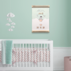 Voorbeeld babykamer met boven het bedje een geboorteposter met pinguïn erop