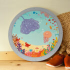 Wandcirkel hout met thema Oceaan. Het lijkt alsof je zo de oceaan in kijkt vanuit een raampje. De zeedieren kunnen gezocht worden en geteld